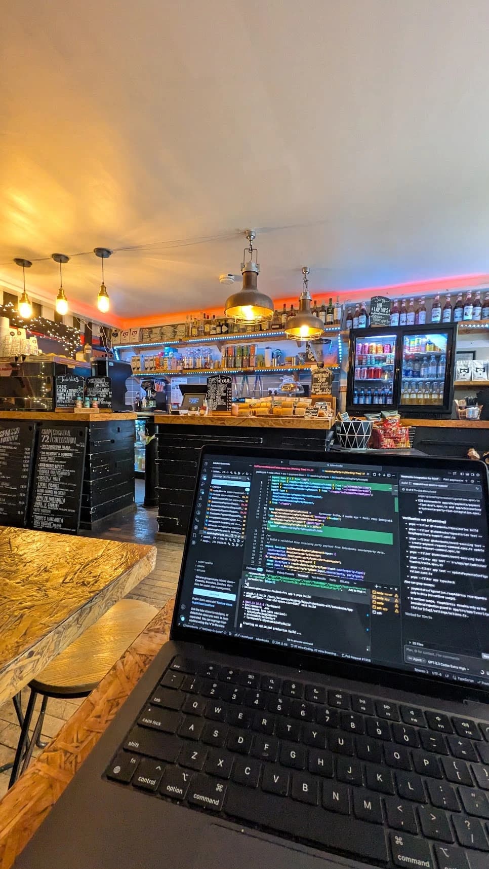 Laptop with the Tokenbooks codebase open, on a table in a cafe
